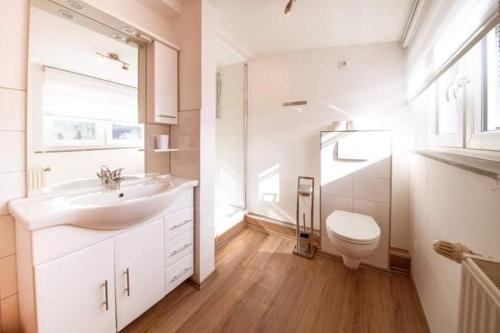 a white bathroom with a sink and a toilet at Pension und China - Thai Restaurant Asia - Haus in Schierke