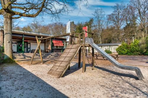 a playground with a slide in front of a building at Stayokay Hostel Apeldoorn - Fully renovated March 2026 in Apeldoorn
