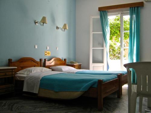 a bedroom with a bed with blue walls and a window at Damias Village in Parikia