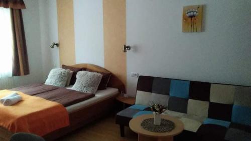 a hotel room with a bed and a couch at Guesthouse Kohári in Egerszalók
