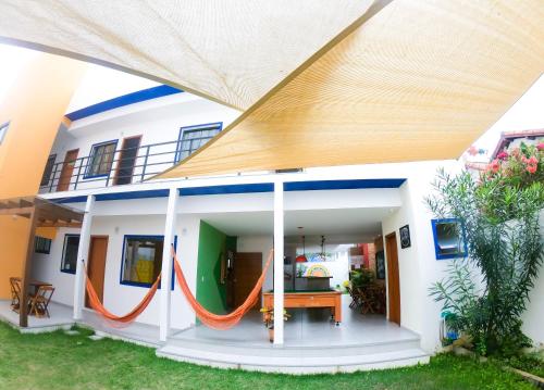una casa con un techo grande con una hamaca naranja en Guest House Cabo Frio, en Cabo Frío