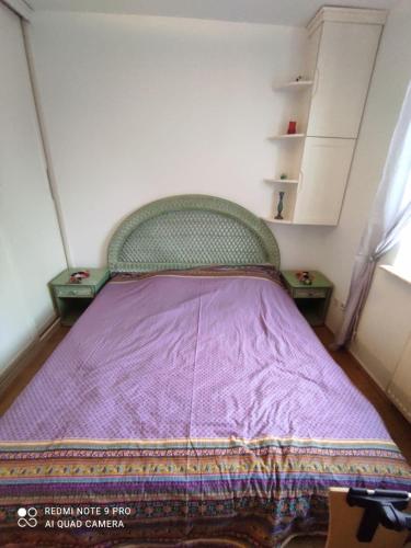 a small bedroom with a bed with a purple blanket at EXCEPTIONAL,ORIENTAL STYLE FLAT close to Warsaw in Mysiadło