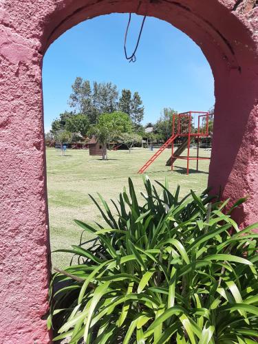 an archway in a wall with a park with a playground at Estancia Renacimiento in Atlántida