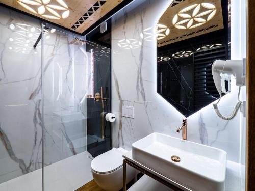 a bathroom with a sink and a toilet at Aparthotel Góralski Spa 2 in Białka Tatrzanska