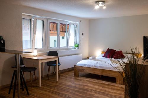 1 dormitorio con 1 cama, escritorio y ventanas en Studio Omis, en Zermatt