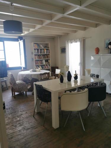 a room with a table and chairs and a living room at Chambres d'hôtes Chez Valérie Garage motos et vélos in Arette