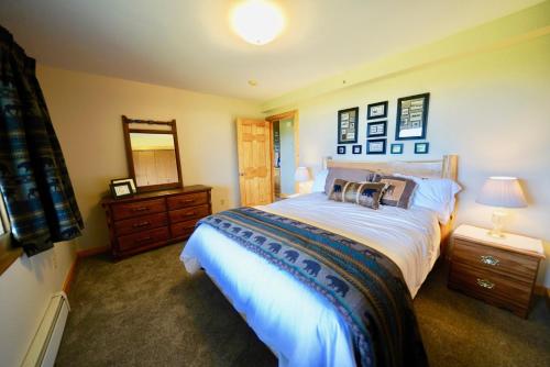 a bedroom with a large bed and a mirror at Flat Fish Lodge B&B and Event Center in Homer