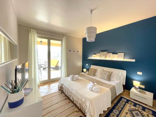 a bedroom with a large bed with a blue wall at Taormina Rooms Panoramic Apartments in Taormina