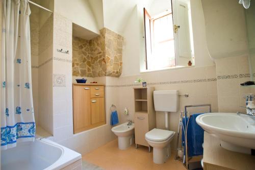 a bathroom with a sink and a toilet and a tub at Il Dammuso nel Vicolo in Scicli