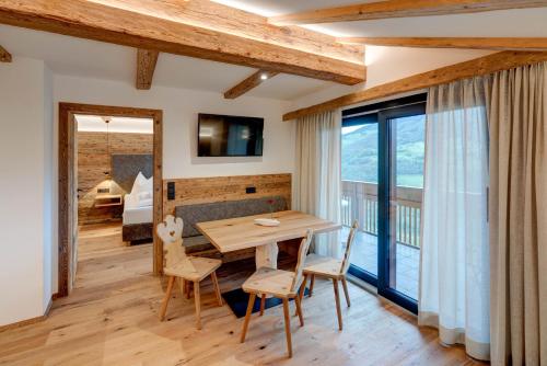 a dining room with a table and chairs and a balcony at Hotel Residence Gasser in Villandro