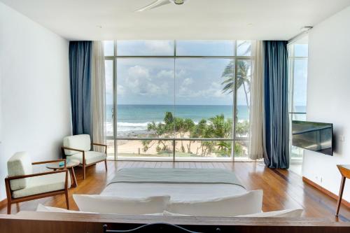 a bedroom with a bed and a view of the ocean at Sielen Diva in Unawatuna