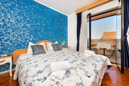Schlafzimmer mit einem blauen und weißen Bett und einem Fenster in der Unterkunft Villa Allegria in Rovinj