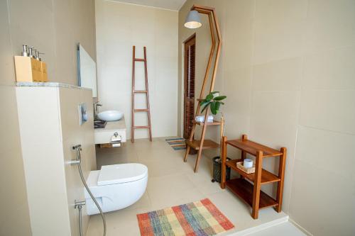 a bathroom with a white toilet and a mirror at Sielen Diva in Unawatuna