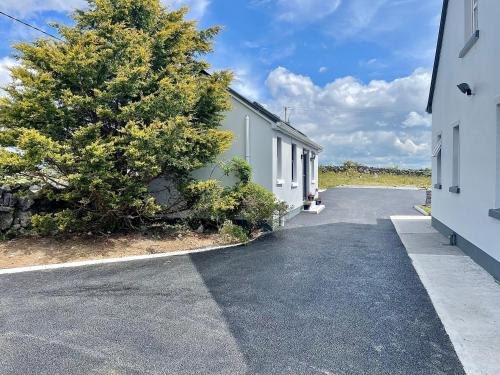 an empty parking lot next to a building with a tree at Tigh Noor - Escape to Kinvara by the sea! in Galway