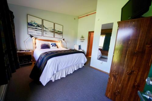 a bedroom with a large bed and a television at Flat Fish Lodge B&B and Event Center in Homer