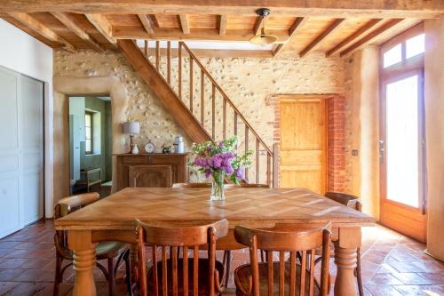 a dining room with a wooden table and chairs at Ecogite Rural La Cle des Champs in Peyrelongue-Abos