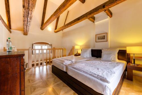 a bedroom with a large bed in a room with wooden ceilings at Schloss Purschenstein in Neuhausen