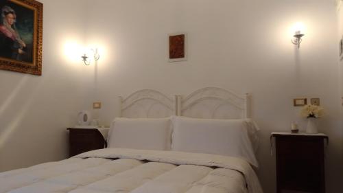 a bedroom with a white bed with white pillows at B&B DIMORA PALMIERI in Monopoli