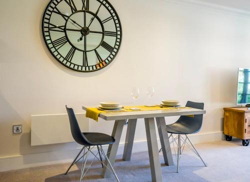 a table with chairs and a large clock on the wall at 26 Cocoa Suites (parking included) in York