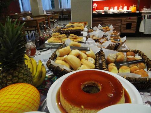a table with many different types of food on it at Emirates Hotel & Suites in Santana do Livramento