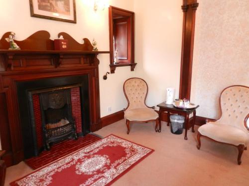 a living room with two chairs and a fireplace at Morangie Hotel Tain in Tain