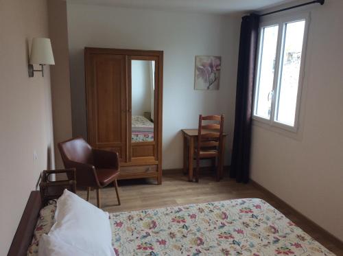a bedroom with a bed and a mirror and a chair at Hotel Restaurant de la Poste in Aullène