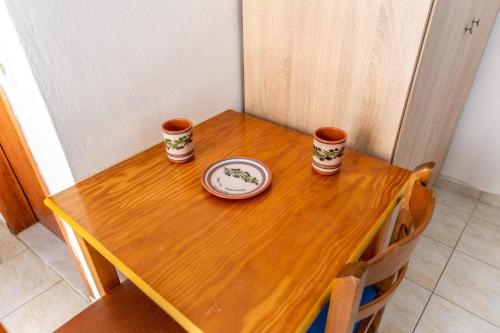 a wooden table with two cups and a plate on it at Kalithies Studios CDK in Kalithies