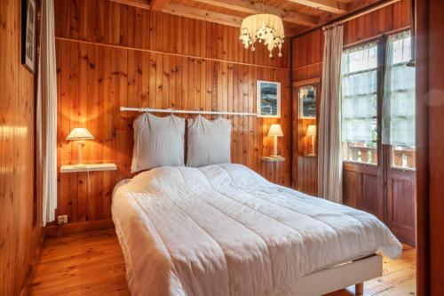 モルジヌにあるChalet Fauvetteの木製の壁に大きなベッドが備わるベッドルーム1室