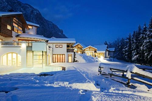 una fila de casas cubiertas de nieve por la noche en Castelir Suite Hotel, en Panchia