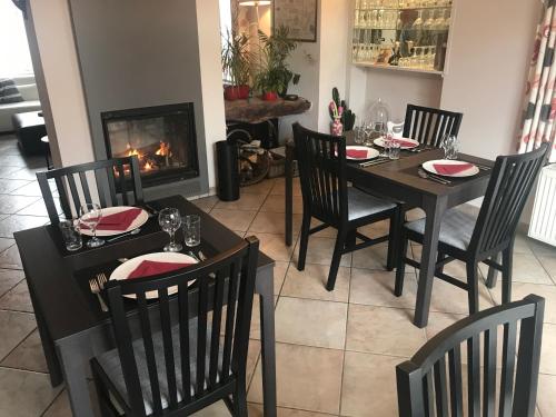 a dining room with a table and chairs and a fireplace at Taos B&B in Vresse-sur-Semois