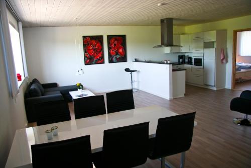 a kitchen and a living room with a table and chairs at Gydensgaard ferielejligheder på Læsø in Læsø