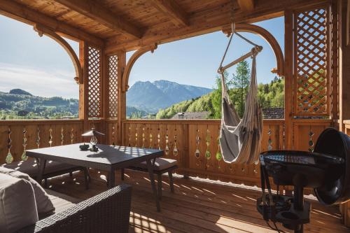 Ferienwohnungen Villa Salzweg في باد غويسرن: غرفة مع أرجوحة على سطح خشبي