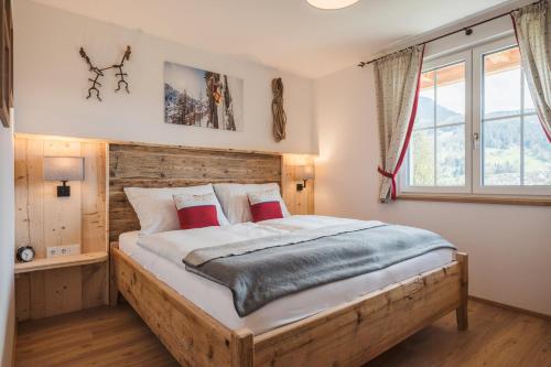 a bedroom with a large wooden bed with red pillows at Ferienwohnungen Villa Salzweg in Bad Goisern