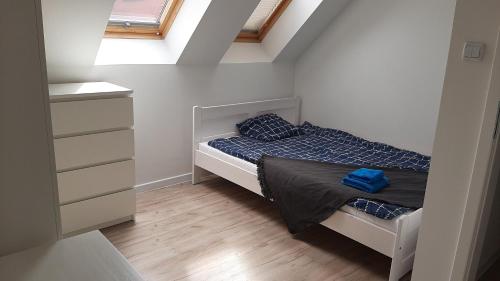 a small bedroom with a bed and a dresser at Kuchciak Apartments in Gdańsk