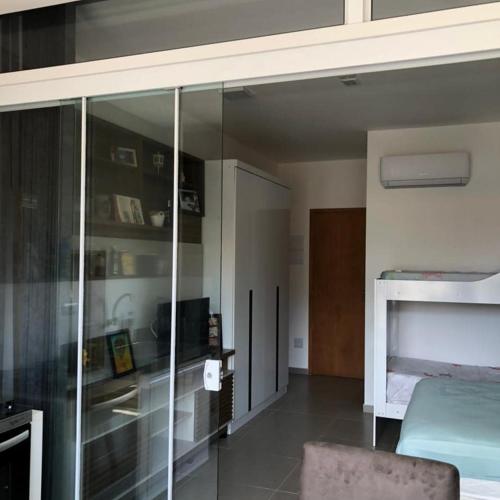 a bedroom with a glass closet and a bed at Recanto Ribas in Ubatuba