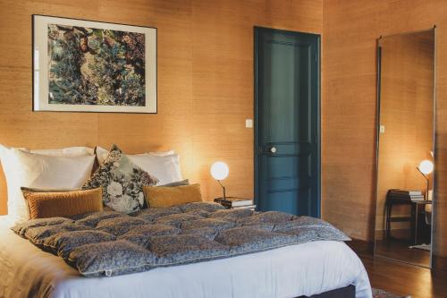 une chambre avec un grand lit et un tableau au mur dans l'établissement La Passerelle de Pont-Aven, à Pont-Aven