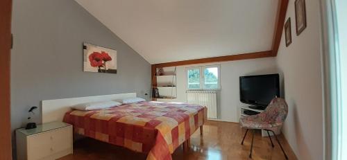 a bedroom with a bed and a television in it at App Milka in Poreč