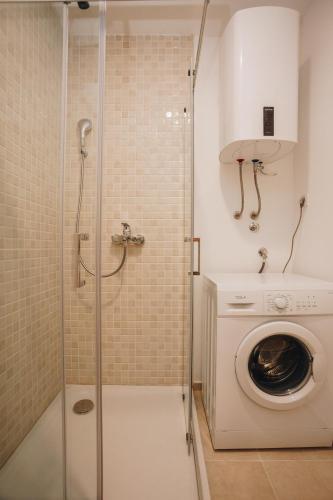 a shower in a bathroom with a washing machine at Status-M Apartments 176 in Bečići