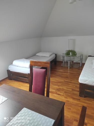 Sala de estar con 2 camas y mesa en Willa na Jurze, en Zarki Letnisko