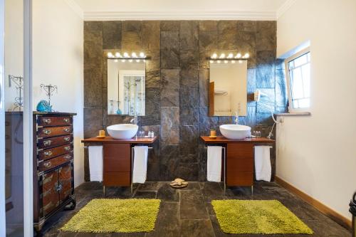 a bathroom with two sinks and two mirrors at Vila Santa Eulália in Albufeira
