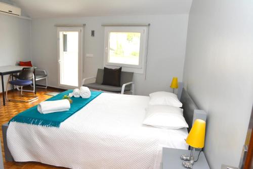 a bedroom with a large white bed and a desk at Casa do Mirante in Porto
