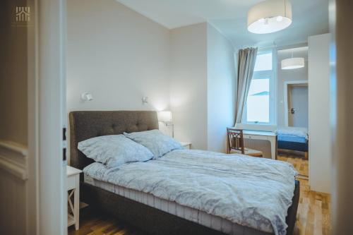 1 dormitorio con cama, escritorio y ventana en Hampton Beach, Seaview, en Sopot