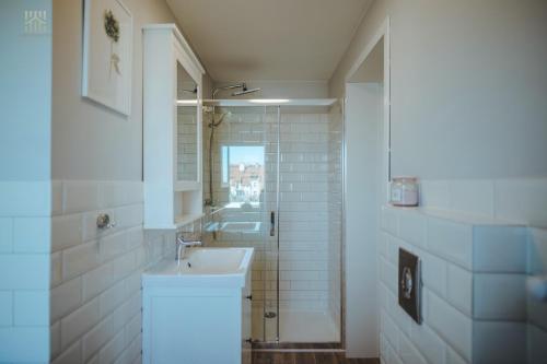 Baño blanco con lavabo y espejo en Hampton Beach, Seaview, en Sopot