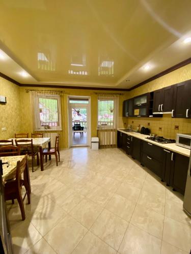 a large kitchen with a table and chairs and a dining room at Приватна садиба Європа in Solochin