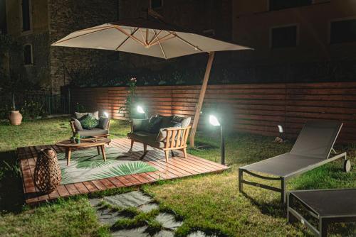 a patio with two chairs and an umbrella at Cà del Mago Pool garden & spa, only adults in Lerici
