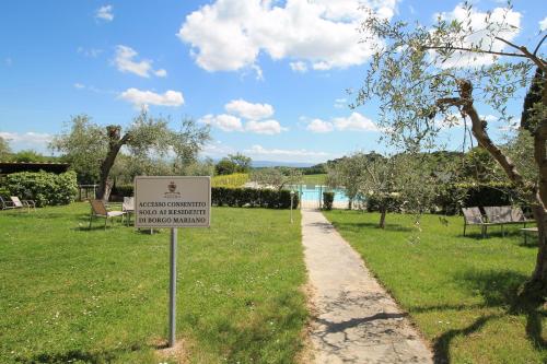 a sign in the grass next to a path at Tenuta Decimo - Il Borgo Di Mariano in San Gimignano