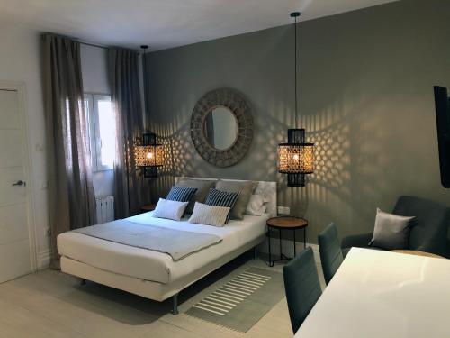 1 dormitorio con cama blanca y espejo en Six Rooms Plaza Mayor en Madrid