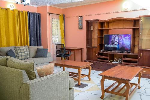 a living room with a couch and a tv at Dondoo's Paradise- Perfect Vacation Home in Kilifi