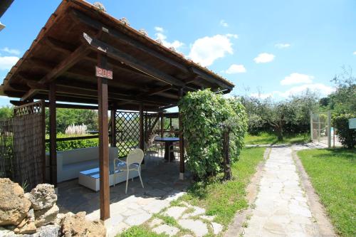 a pavilion with a table and a chair in a garden at Tenuta Decimo - Il Borgo Di Mariano in San Gimignano