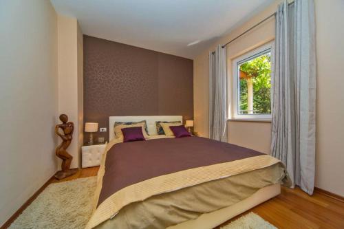 a bedroom with a large bed and a window at BLUE DREAM - Stylish Apt with stunning sea view in Dubrovnik